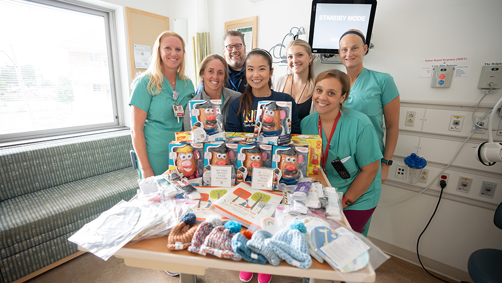 group of people posing for a photo with toys