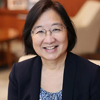 Portrait of Tina Cheng ’83 MD’86, PMD’22 wearing a dark coat while seated.