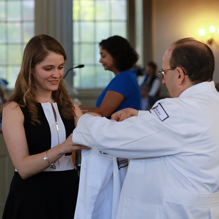 Student accepting white coat
